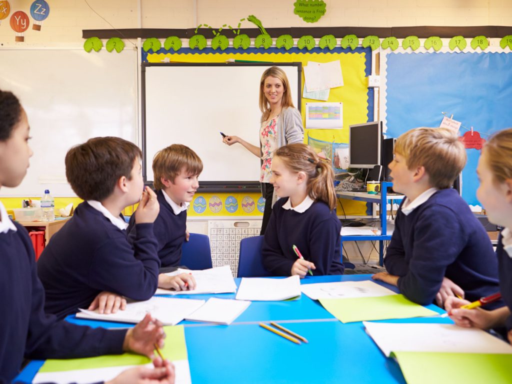 Teacher working with a small group of students at a classroom table
