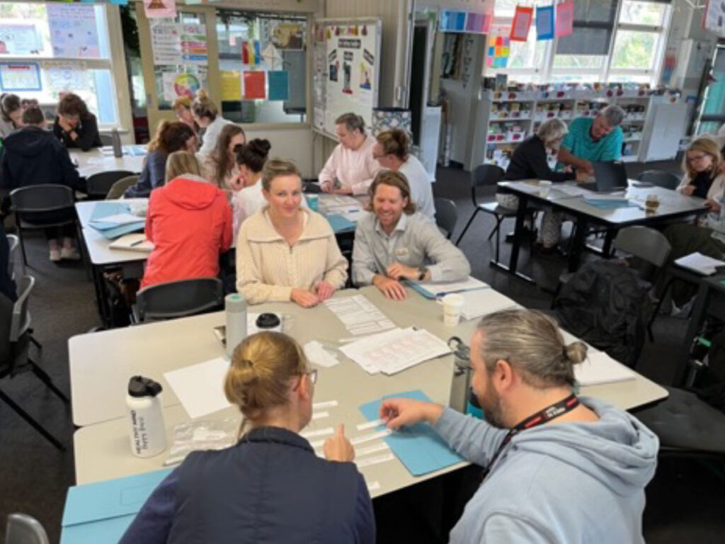 Teachers discussing literacy practice in small groups during professional learning