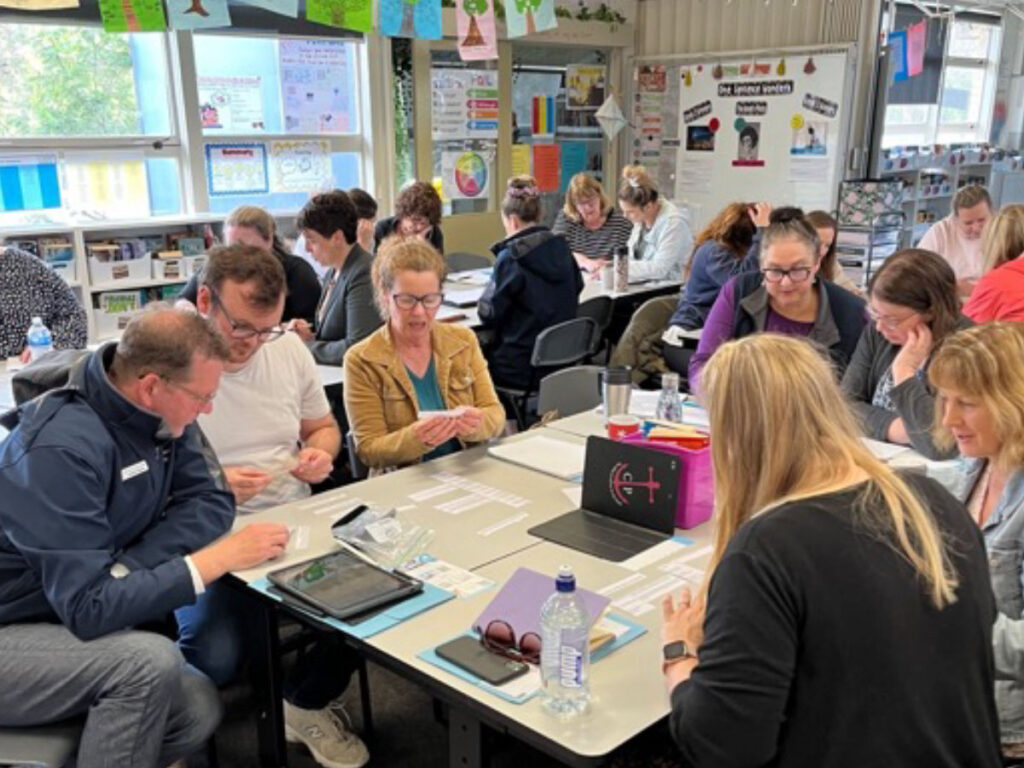 Teachers working in small groups at a literacy professional learning day